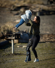 Load image into Gallery viewer, woman lifting up a child while wearing a leg brace
